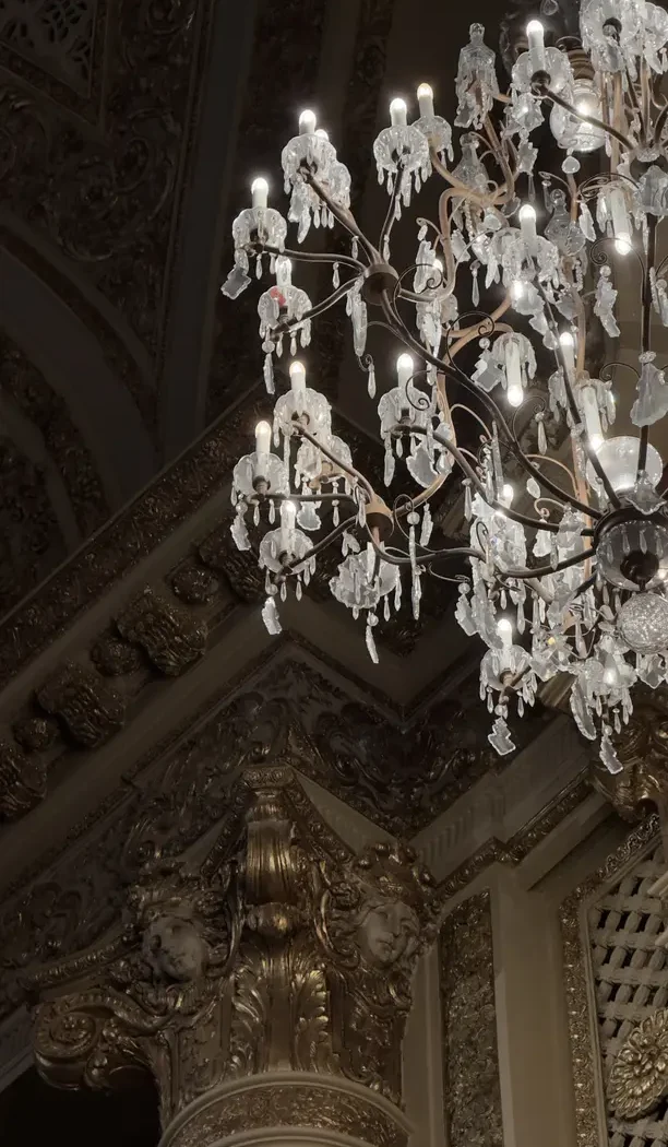 An ornate crystal chandelier in a grand old money interior